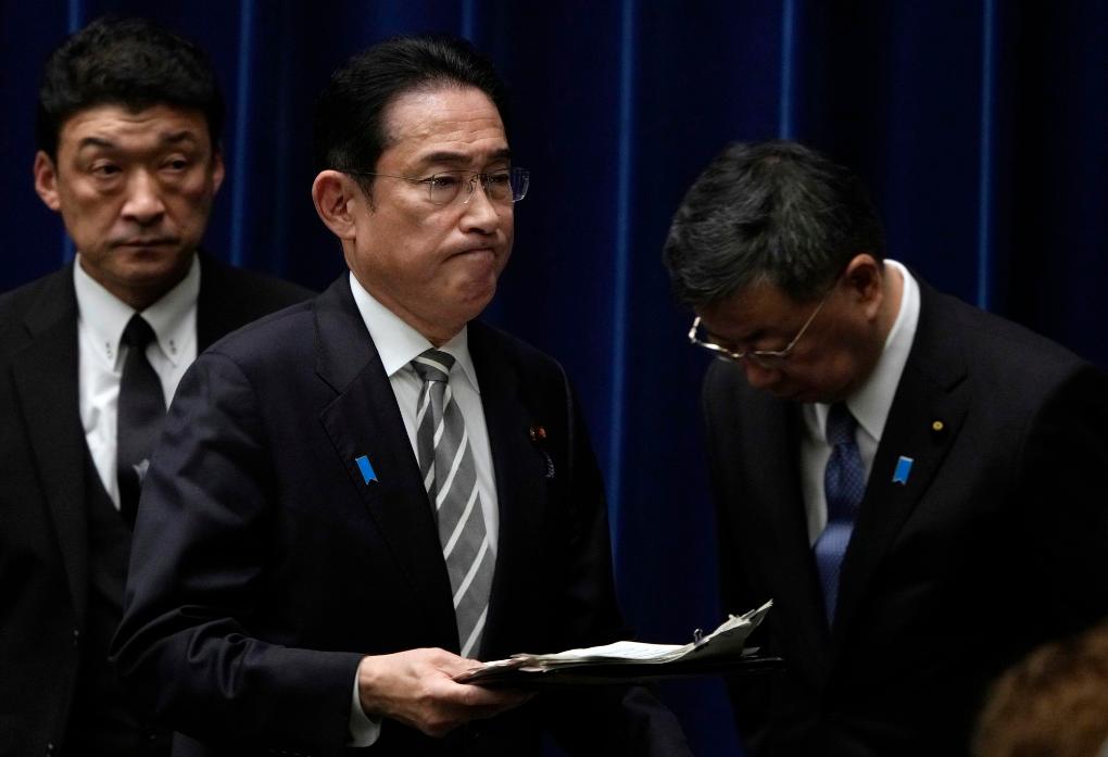 2023年12月13日,日本首相岸田文雄(中)在日本东京首相官邸召开记者会后走过时任内阁官房长官松野博一(右)。新华社发(Pool图片,弗兰克·罗比雄摄)