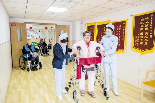 3月1日，秦皇岛市北戴河区平安秦康颐养中心，老人在工作人员的帮助下进行康复训练本。报记者 赵杰摄