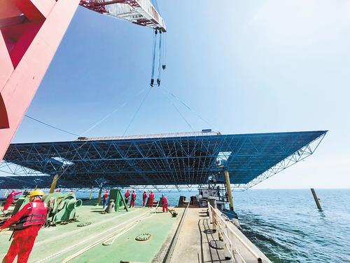 8月26日，在河北华电昌黎500兆瓦海上光伏试点项目现场，工人们正在吊装光伏板网架。 本报记者 孙也达摄
