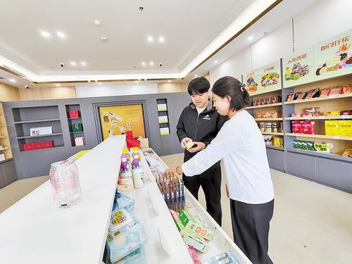 10月11日,雄安保税商品直购体验店工作人员(左)向消费者介绍保税商品。 本报见习记者 康晓博摄