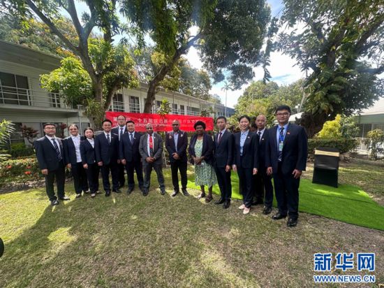 莫尔兹比港,2025年10月15日,第14批、第15批中国援巴布亚新几内亚医疗队在莫尔兹比港总医院举行交接仪式,并与巴新卫生部副秘书多拉·兰图鲁特(右五)、莫港总院CEO帕基·莫鲁米(右七)、莫港总院医务处处长索比·科内(右六)合影。易若曈 摄