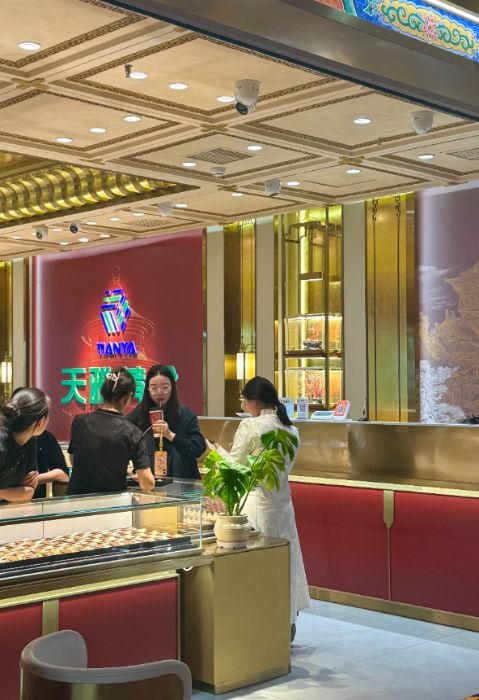 10月28日，在北京市天雅珠宝城某品牌柜台，顾客正在挑选黄金饰品。新华网记者 闫雨昕 摄