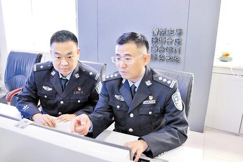 10月30日,许俊富(右)与同事在分析案情。 本报记者 桑珊摄