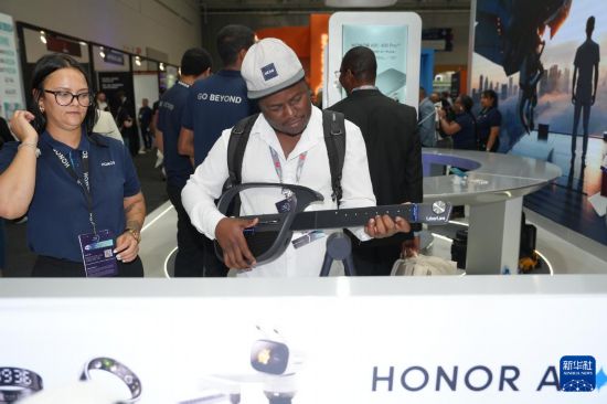 11月11日，在南非开普敦，一名参观者在2025年非洲科技节上体验智能电子吉他。新华社记者 王雷 摄