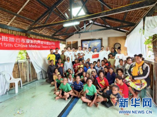11月17日，第15批援巴布亚新几内亚中国医疗队在巴新首都莫尔兹比港为当地孤儿和贫困儿童提供义诊服务。图为医疗队员与当地儿童、福利机构工作人员合影。（第15批援巴布亚新几内亚中国医疗队供图）