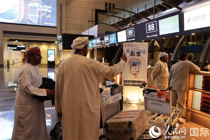 11月30日晚，在马斯喀特国际机场，准备前往北京的阿曼旅客正在办理值机手续。人民网记者 张志文摄