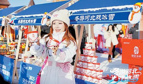 “河北欢乐冰雪旅游季”活动现场,游客正在保定冰柿展台前拍照留念。洪波摄
