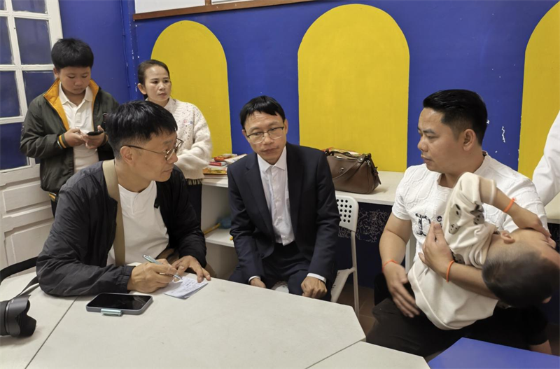 患者家属(右一)向记者讲述孩子在中国治疗的情况。段春雨摄