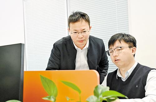 12月3日，雄安兴元科技有限公司创始人巩文通（左）和同事进行技术交流。 本报记者 刘光昱摄