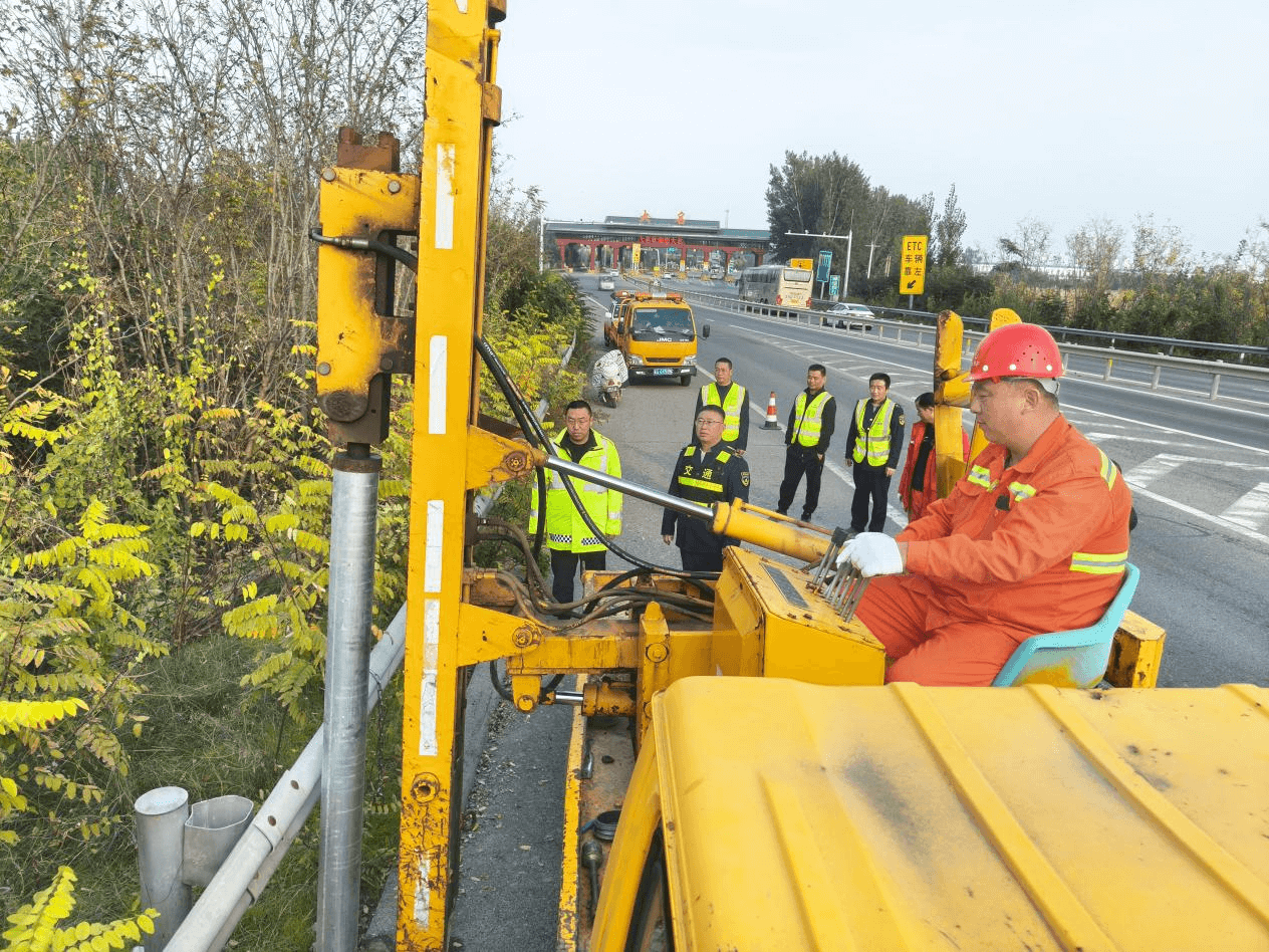 工作人员操作作业车安装自动封路装置的护栏立柱。王瑞娜摄