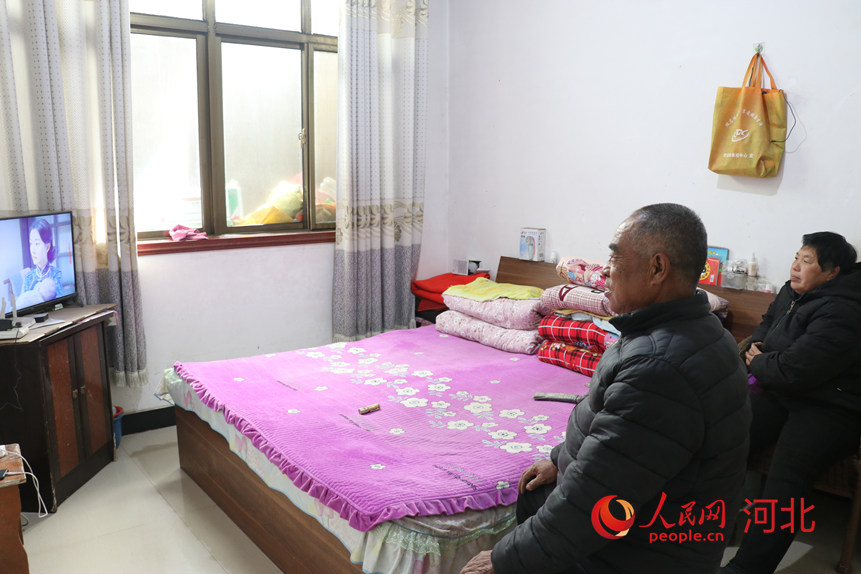 河北赞皇县墙板沟自然村民李占福和老伴儿在家看电视。人民网记者 祝龙超摄