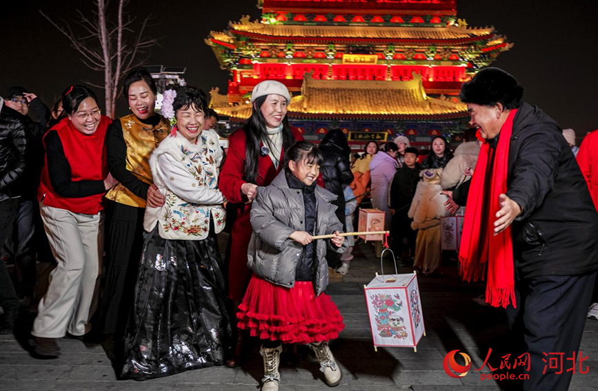 手提灯笼的孩子在长辈的陪伴下感受传统年味。人民网记者 方童摄